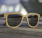 Iris hemp sunglasses with Shaded Black lenses, front view on a weathered dock