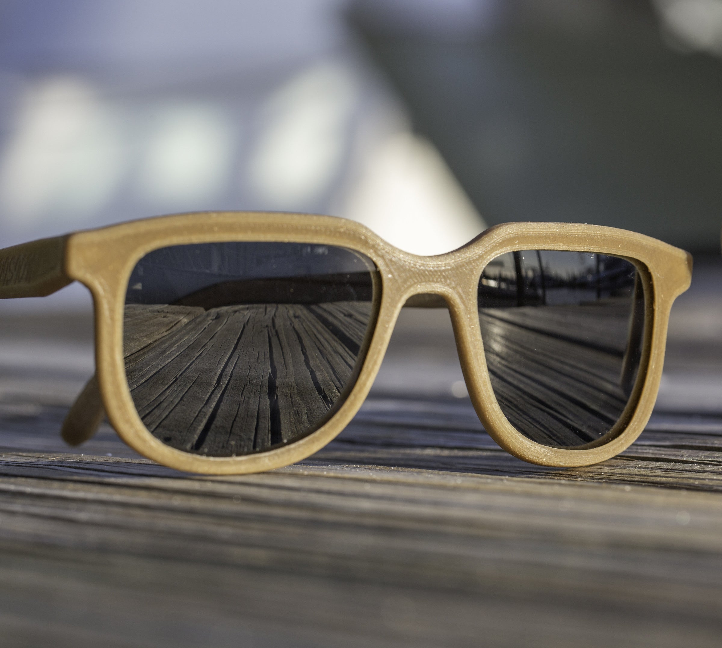 Iris hemp sunglasses with Shaded Black lenses, front view on a weathered dock